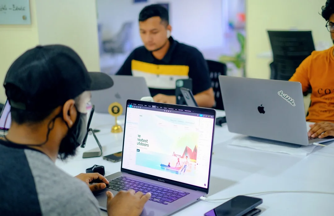 Man working on web design in a home office setup with dual monitors.