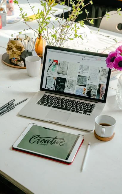 Un bureau de travail élégant, aménagé avec des appareils Apple : iMac, MacBook et iPad.